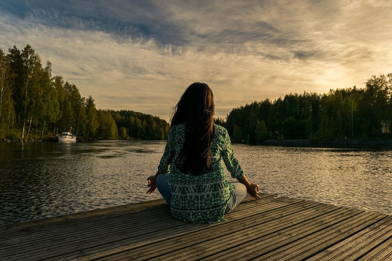 Woman practicing yoga and meditation at sunset